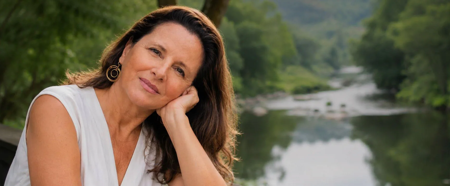 Paula Urbano junto a um rio, com o olhar sereno.